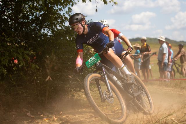 Rider railing a dusty corner as the crowd looks on